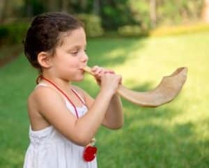 girl blowing a shofar