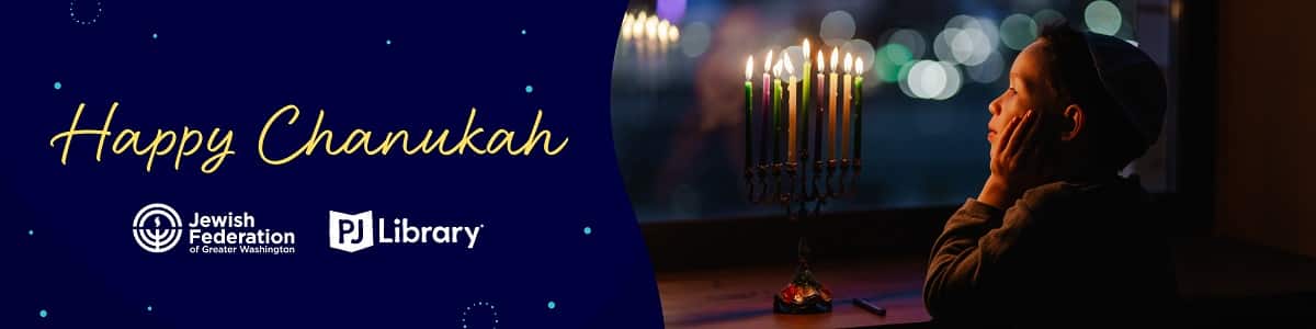 Happy Chanukah Banner with young child looking at lit menorah and candles reflecting in window.