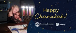 Happy Chanukah greeting graphic with two girls hugging and looking at a lit menorah